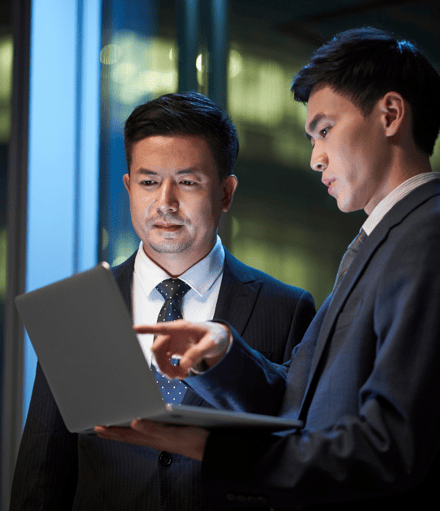 two people discussing over a laptop