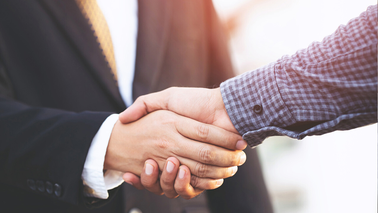 Image of a man in a suit shaking hands with another person