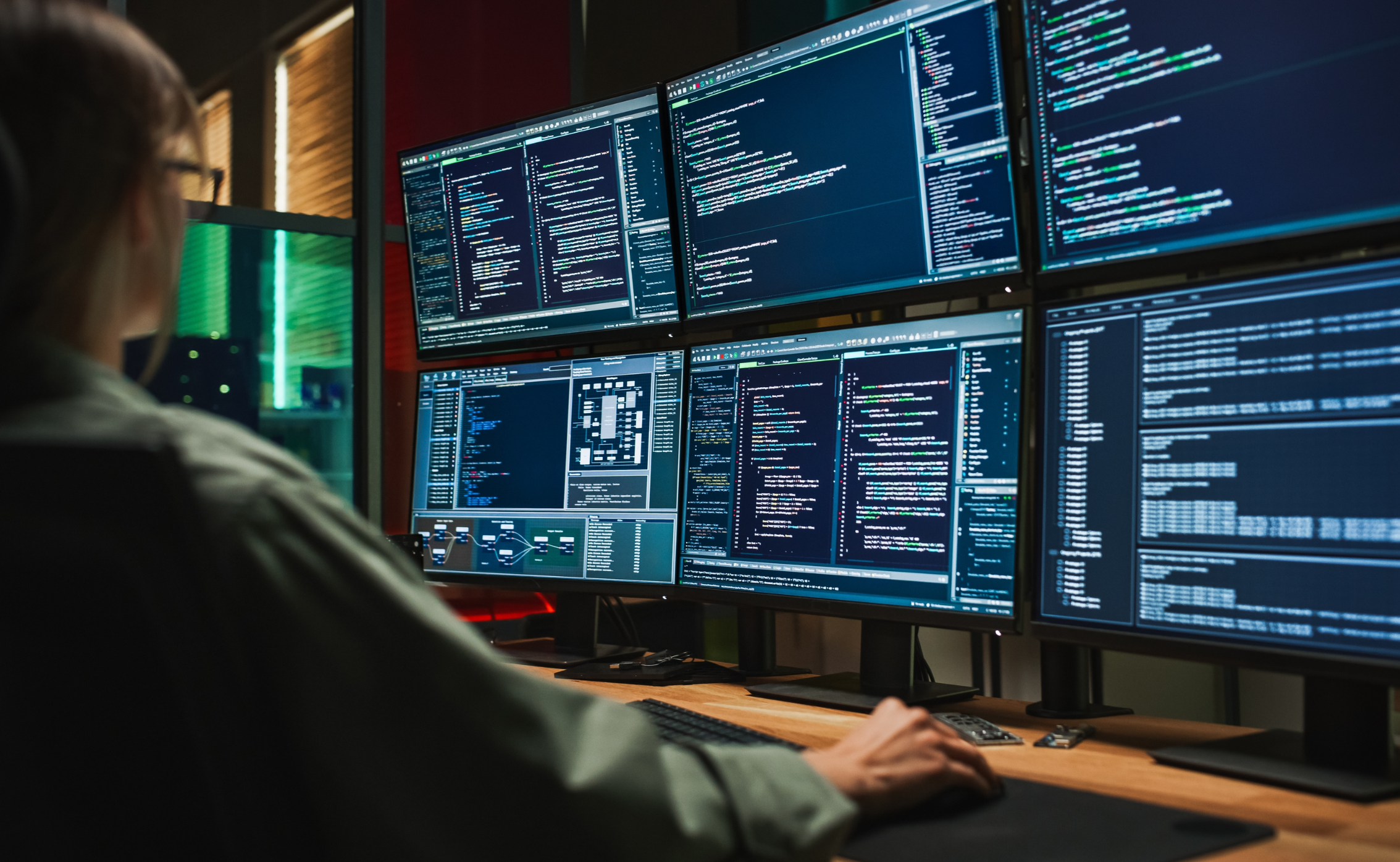 a person coding on multiple screen for enhancing cybersecurity