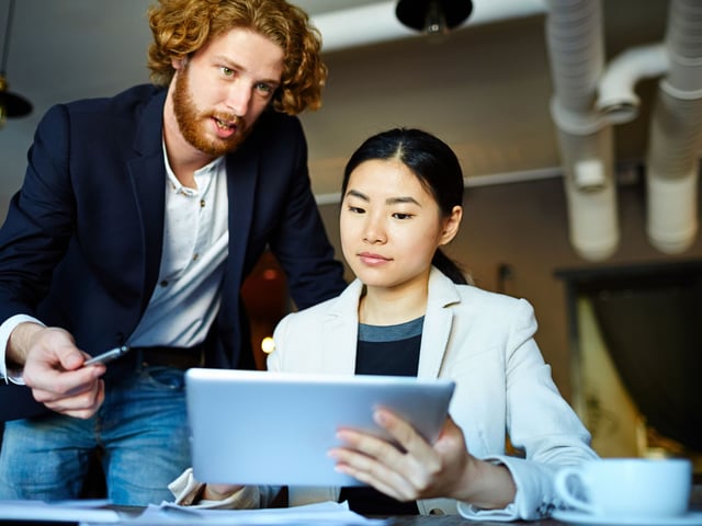 Two co-workers looking at a tablet