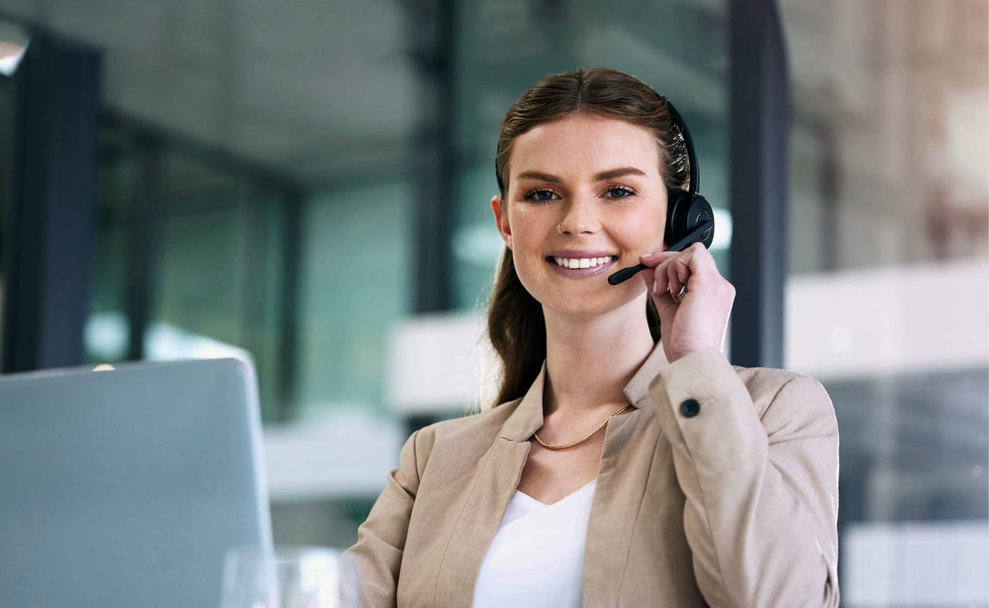 A female customer service employee with a headset processing a customer query